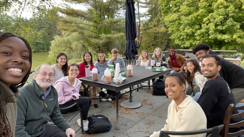 Students and Dr. David Silbersweig gathered on a deck