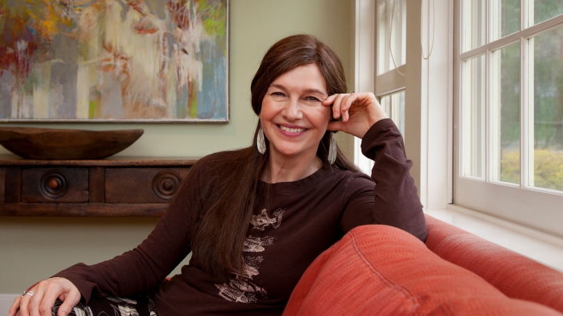 Louise Erdrich '76 sits on a couch at Dartmouth's Montgomery House